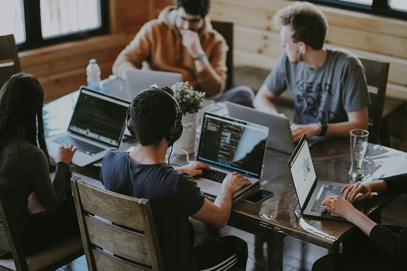 Pessoas trabalhando em notebooks em uma mesa compartilhada